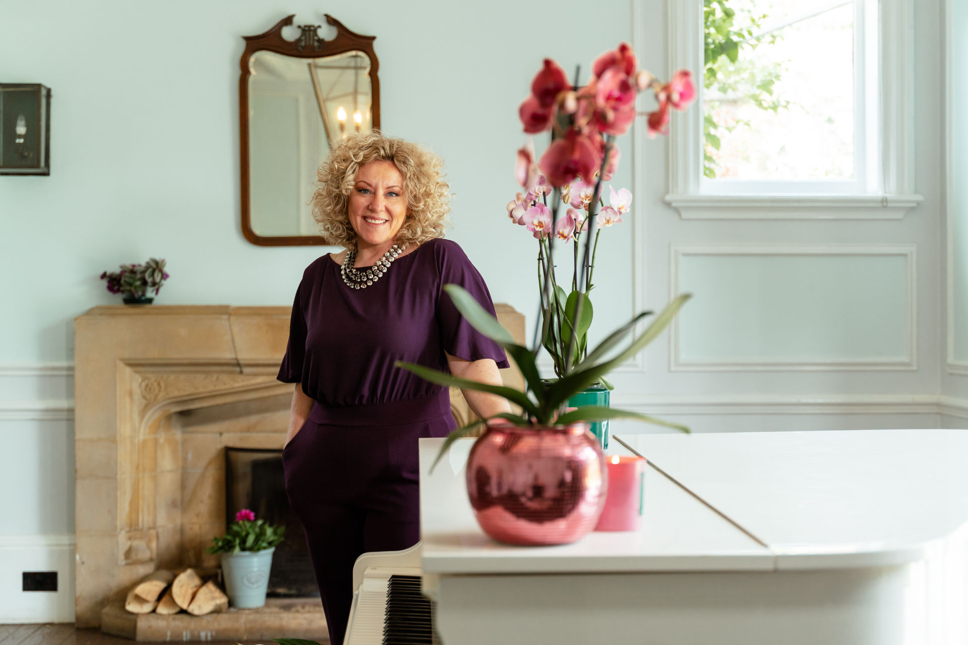 Cotswolds Wedding Pianist Emma, dressed in purple, with a white grand piano
